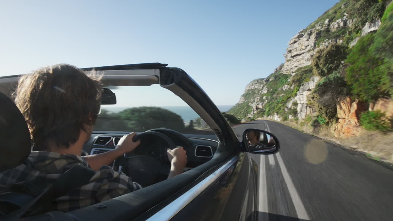 pareja conduciendo un coche descapotable cabriolet ciudad del cabo sudáfrica steadicam tiro