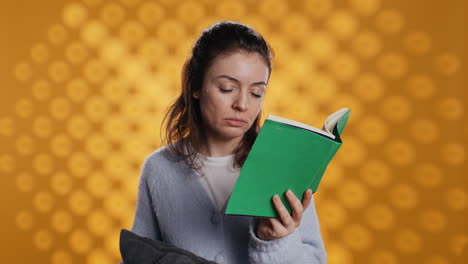 Mujer-Soñolienta-Que-Lucha-Por-Mantener-Los-Ojos-Abiertos-Mientras-Lee-Un-Libro,-Fondo-De-Estudio