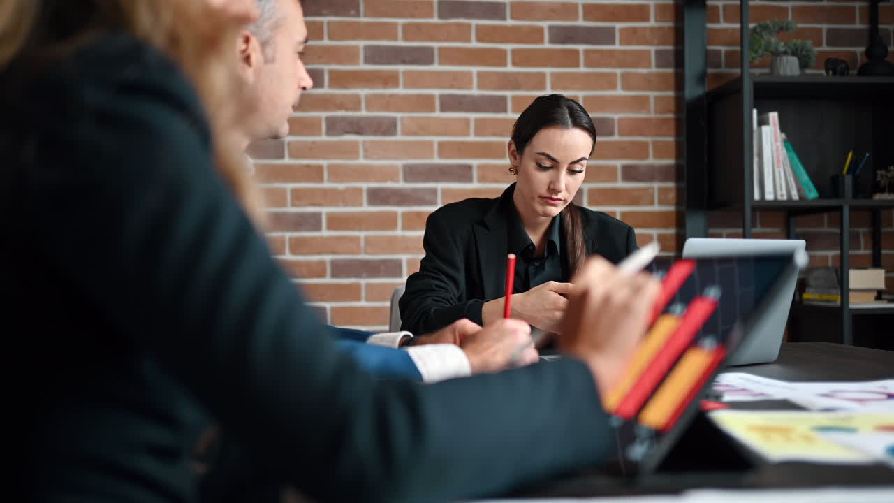 Coworkers talking at a table in an office