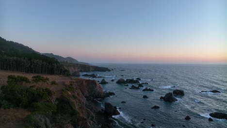 Wide-aerial-view-of-the-Northern-California-coast-at-sunset-with-large-rocks-spread-throughout-the-water