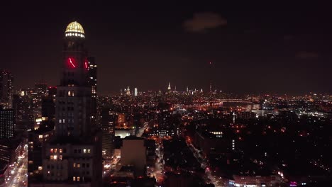 drone footage of the brooklyn and manhattan city skyline at night, taken from brooklyn new york
