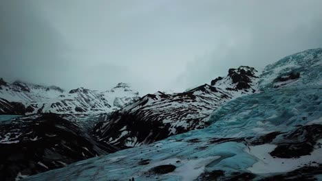 vista aérea de drones de personas haciendo senderismo en el enorme campo de glaciares azules en islandia, tierra de fuego y hielo