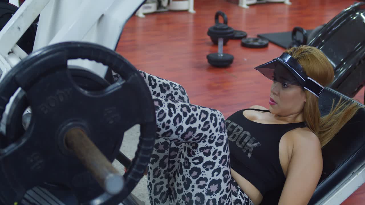 Fitness woman leg press in sports wear at a gym in the Caribbean