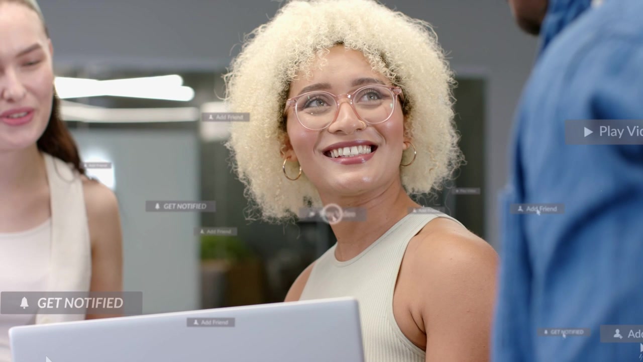 Donna seduta che usa un laptop, avvia la riproduzione per una revisione aziendale, con badge UI che si muovono sopra il team.