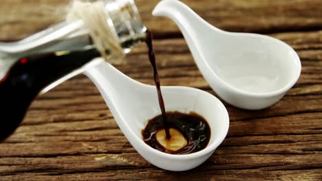 soy sauce being poured into appetizer spoon