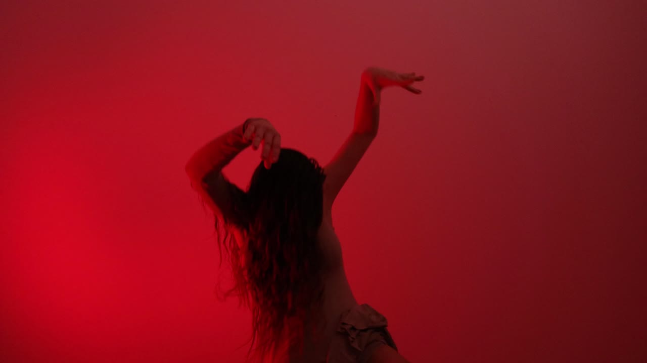 una joven bailarina de ballet está bailando con una danza temporal en un ensayo en una habitación oscura por la noche