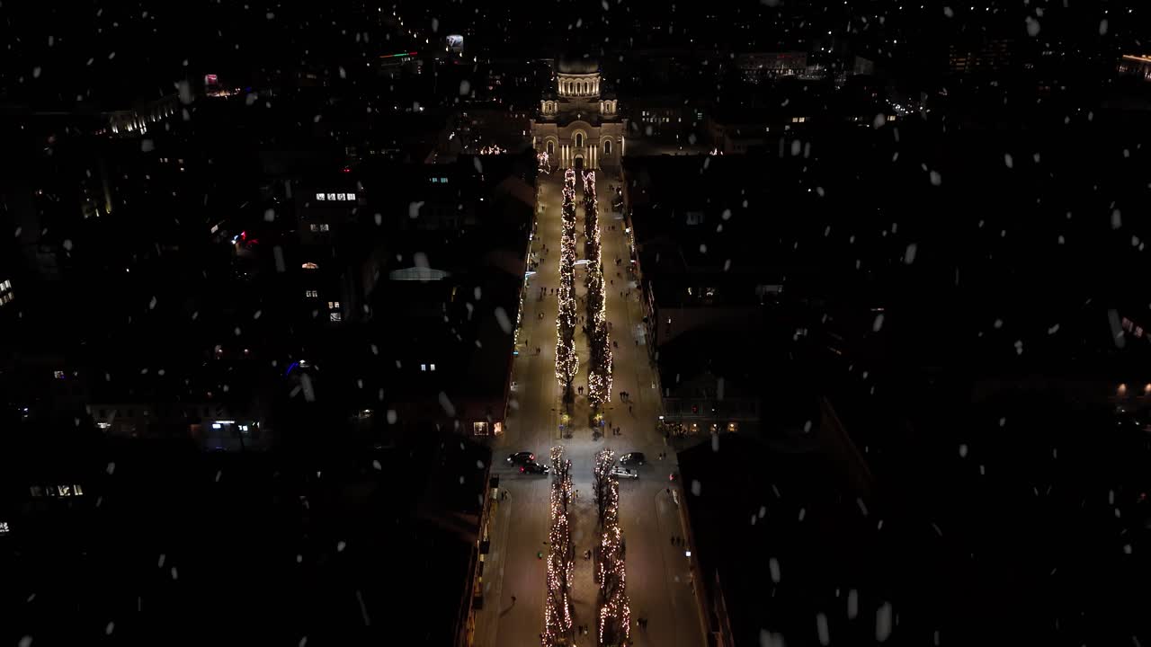 Freedom Alley with Christmas decorations at night during snowfall, aerial view
