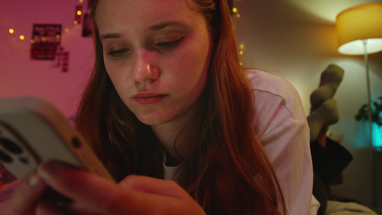 침대에서 드폰을 사용하는 미소 짓는 젊은 여성