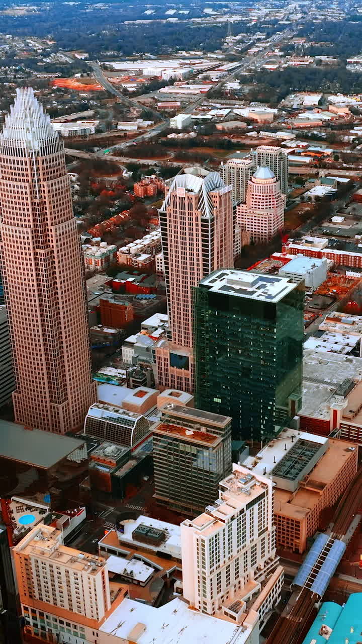 Gruppo di grattacieli che spiccano nell'architettura a bassa altezza del paesaggio urbano americano. Charlotte, Carolina del Nord, USA vista dall'alto. Video verticale