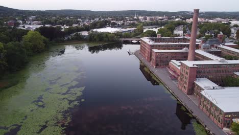 una histórica fábrica de relojes y chimenea al lado del río charles en waltham, massachusetts