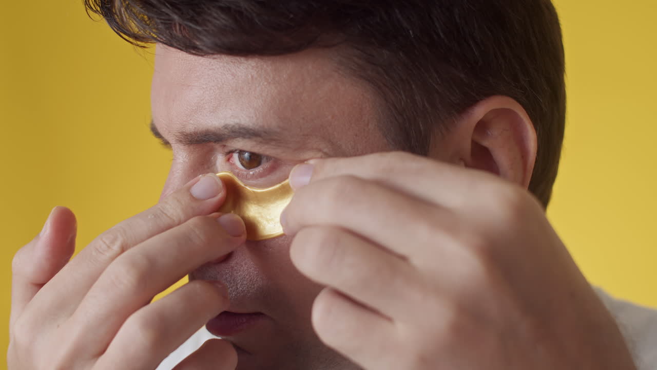 Middle-aged Man Wearing Golden Hydrogel under Eye Patches