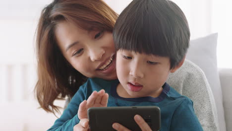 asian mother and child using smartphone having video chat little boy with mom waving sharing vacation weekend with son enjoying chatting on mobile phone 4k footage