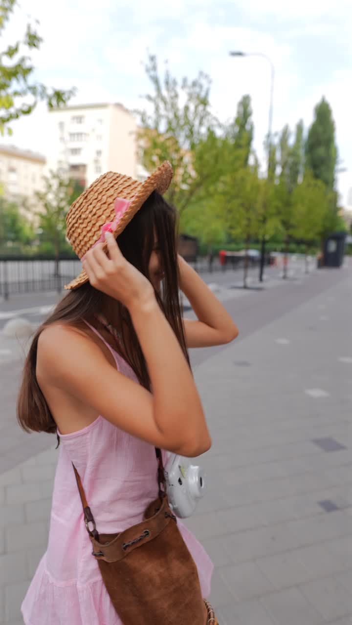 모자와 인스턴트 카메라를 가진 젊은 여성