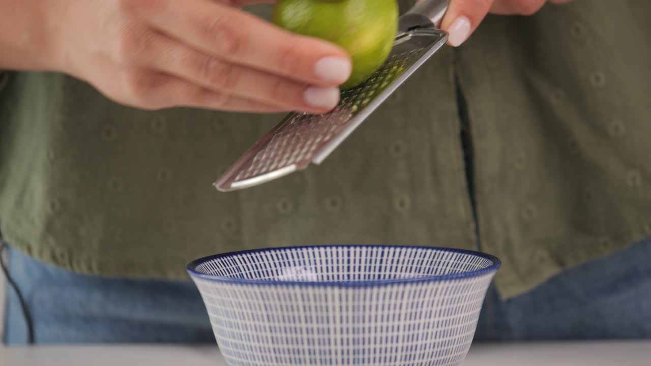 Grattugiare la scorza di un lime con una grattugia da cucina