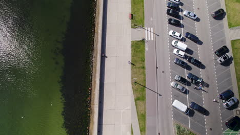 ascender descripción aérea que muestra gente caminando, la costa del mar báltico y el área de estacionamiento con autos en gdynia durante el día soleado