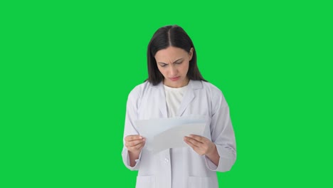 estresada mujer científica india leyendo informes pantalla verde