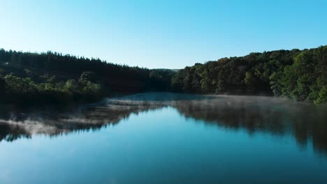 Temprano-En-La-Mañana,-Un-Dron-Bajo-Disparó-Sobre-Un-Lago-Brillante-Con-Algo-De-Niebla-Y-Pájaros