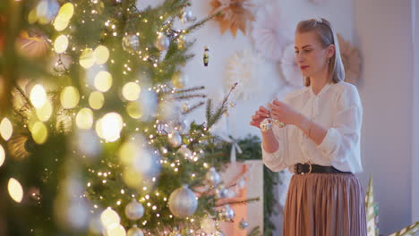 woman decorates christmas tree during family christmas