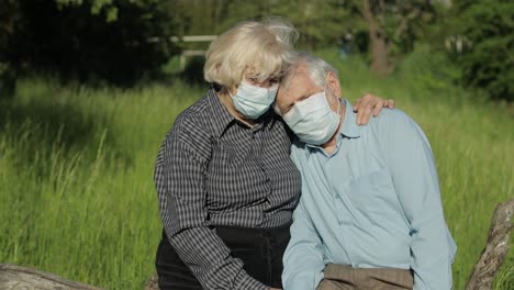 una pareja de ancianos con máscaras médicas durante la cuarentena por coronavirus covid-19 en un parque