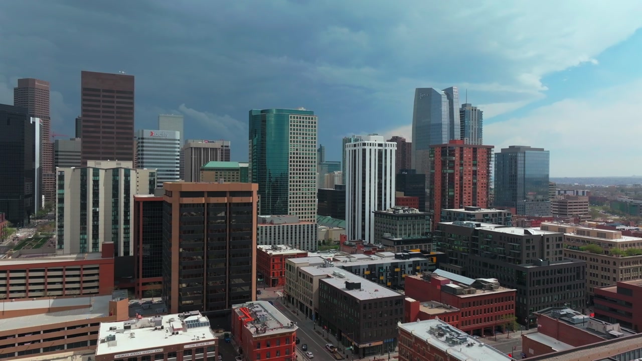 Downtown Lodo Denver Colorado aerial drone parallax cityscape landscape summer spring rooftops tall skyscraper buildings Larimer Square sunny blue sky afternoon stormy clouds street upwards motion