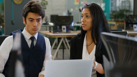 Executives-discussing-over-laptop-in-the-office-4k