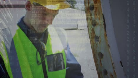 pantalla con procesamiento de datos contra un ingeniero caucásico que usa una tableta digital
