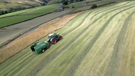 Hermoso-Punto-De-Vista-Aérea-De-Un-Tractor-De-Cosecha-Con-Rollo-Negro-Que-Funciona-En-Un-Amplio-Campo-De-Hierba-En-Verano