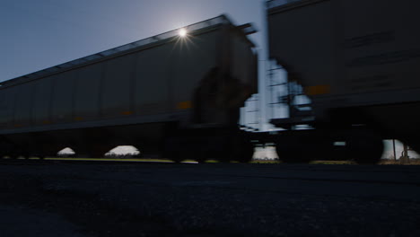 tren de carga que pasa por las tierras de cultivo estadounidenses al atardecer