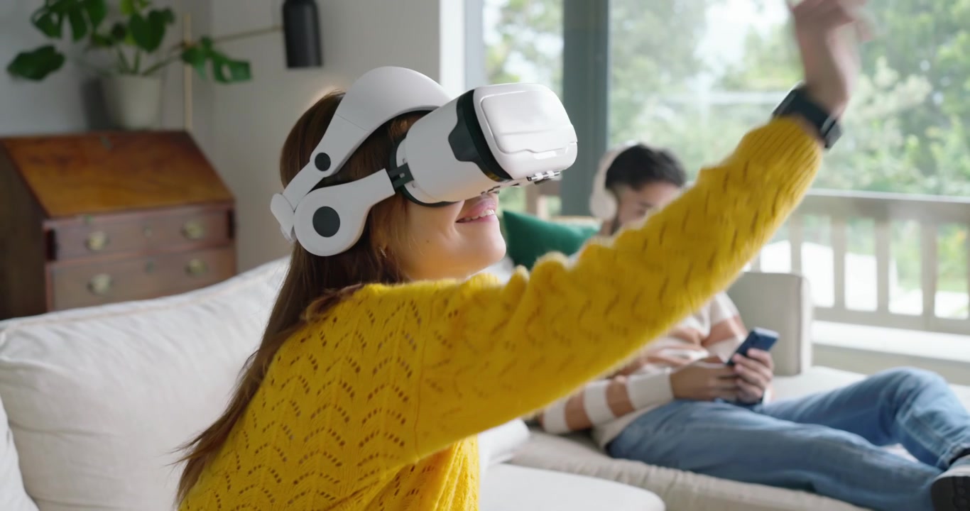 Donna afroamericana di una coppia con visore VR bianco che si attiva, gesticolando per navigare nel menu a casa.