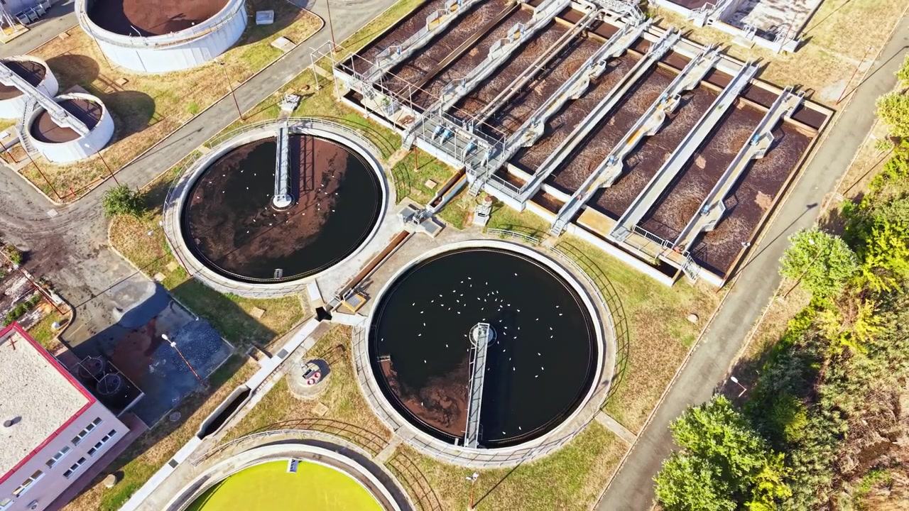 Water treatment facility with multiple tanks and equipment viewed from above during daylight hours