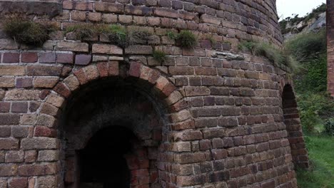 Panning-across-overgrown-Porth-Wen-deserted-brickwork-ruins-and-rusty-iron-boiler