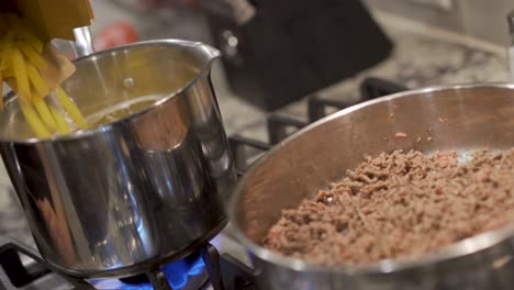 pouting pasta in pot with ground beef