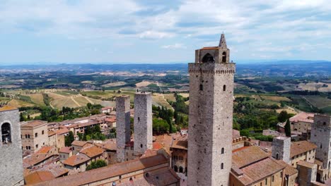 cinematic drone shot of san gimignano’s famous skyline with its medieval towers and sweeping tuscan hills in golden daylight.