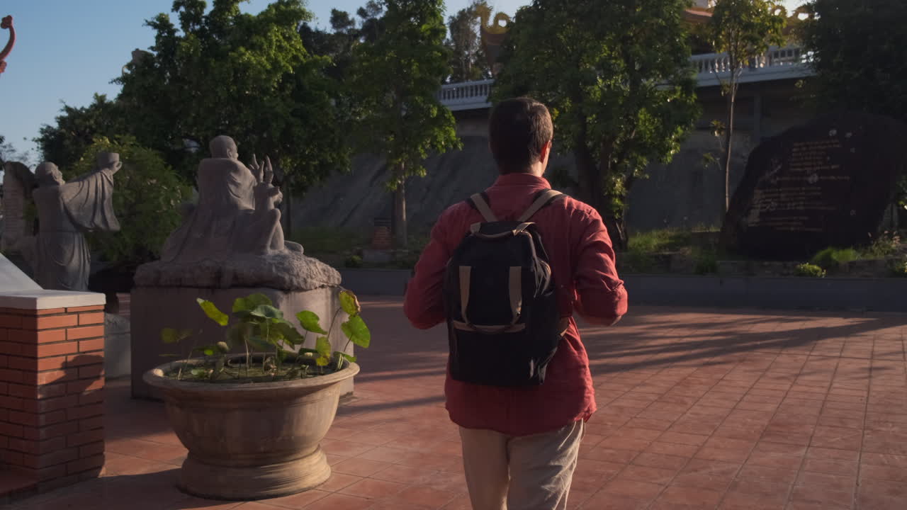 Man Walking Through a Temple Garden