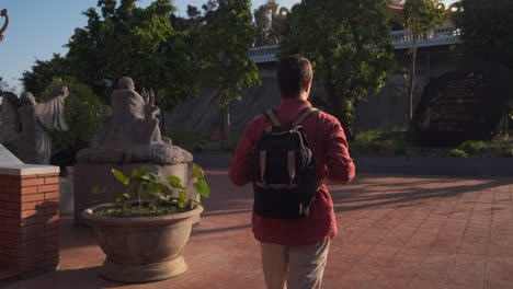 man walking through a temple garden