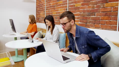 Grupo-De-Ejecutivos-Trabajando-Con-Dispositivos-Electrónicos-En-El-Escritorio