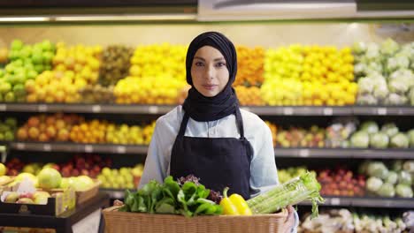 Porträt-Einer-Frau-Im-Hijab,-Die-Mit-Einem-Korb-Mit-Frischem-Gemüse-Im-Supermarkt-Steht