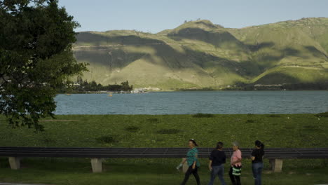 scenic lake landscape with mountains and people walking along the shore