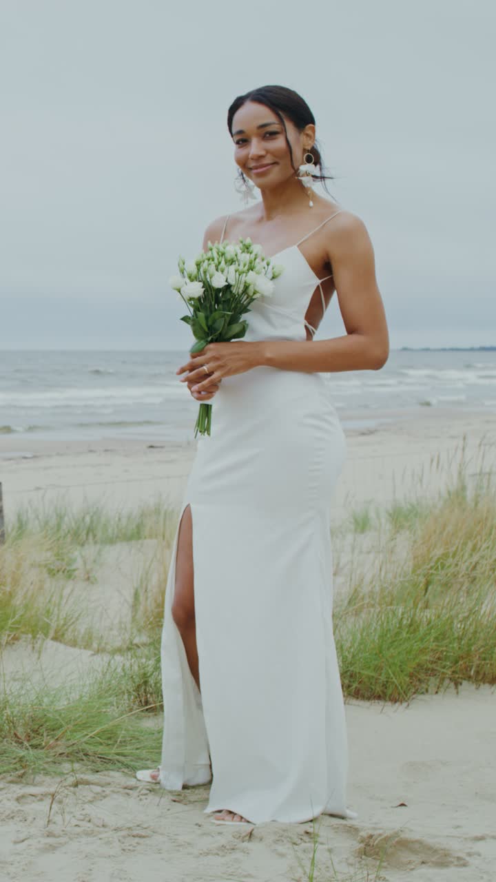 Sposa sulla spiaggia con bouquet