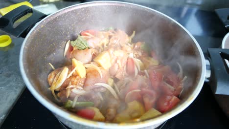 cooking chicken and vegetables in a pan