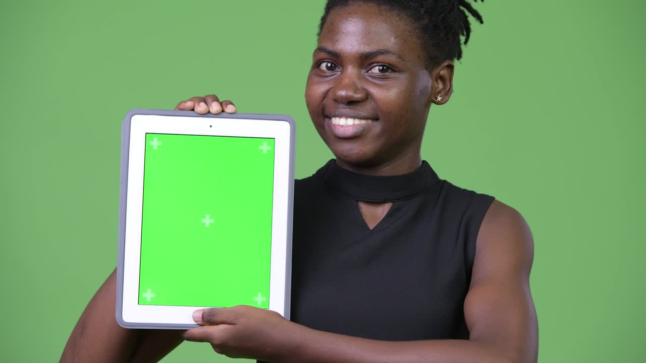 Giovane e bella donna d'affari africana che mostra un tablet digitale