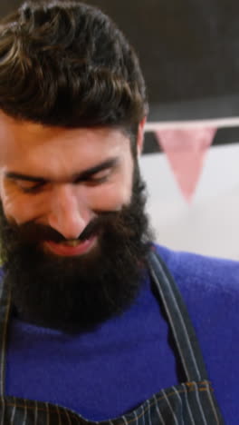 el personal masculino sonriente sosteniendo una caja de verduras frescas en el supermercado