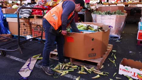 worker chopping corn at melbourne market stall