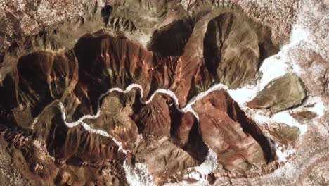 Drone-shot-landing-on-salt-lake-remains-of-salt-river-in-hot-dry-desert-climate-in-Iran-natural-landscape-vivid-colorful-scenic-panoramic-amazing-nature-wonders-in-brown-color-mountain-cliff-rock-view