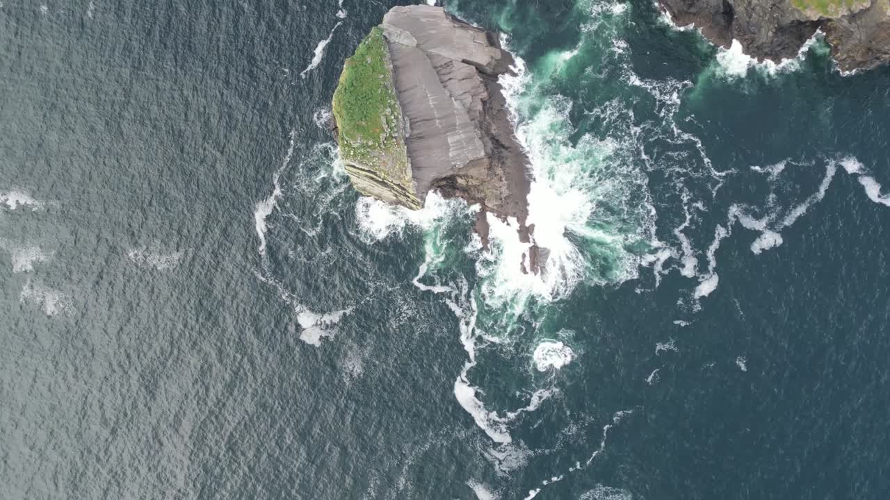 vista aérea acantilado que se encuentra con el mar turbulento, olas que chocan contra la orilla
