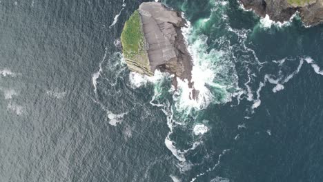 Vista-Aérea-Del-Acantilado-Que-Se-Encuentra-Con-El-Mar-Turbulento,-Olas-Rompiendo-Contra-La-Orilla