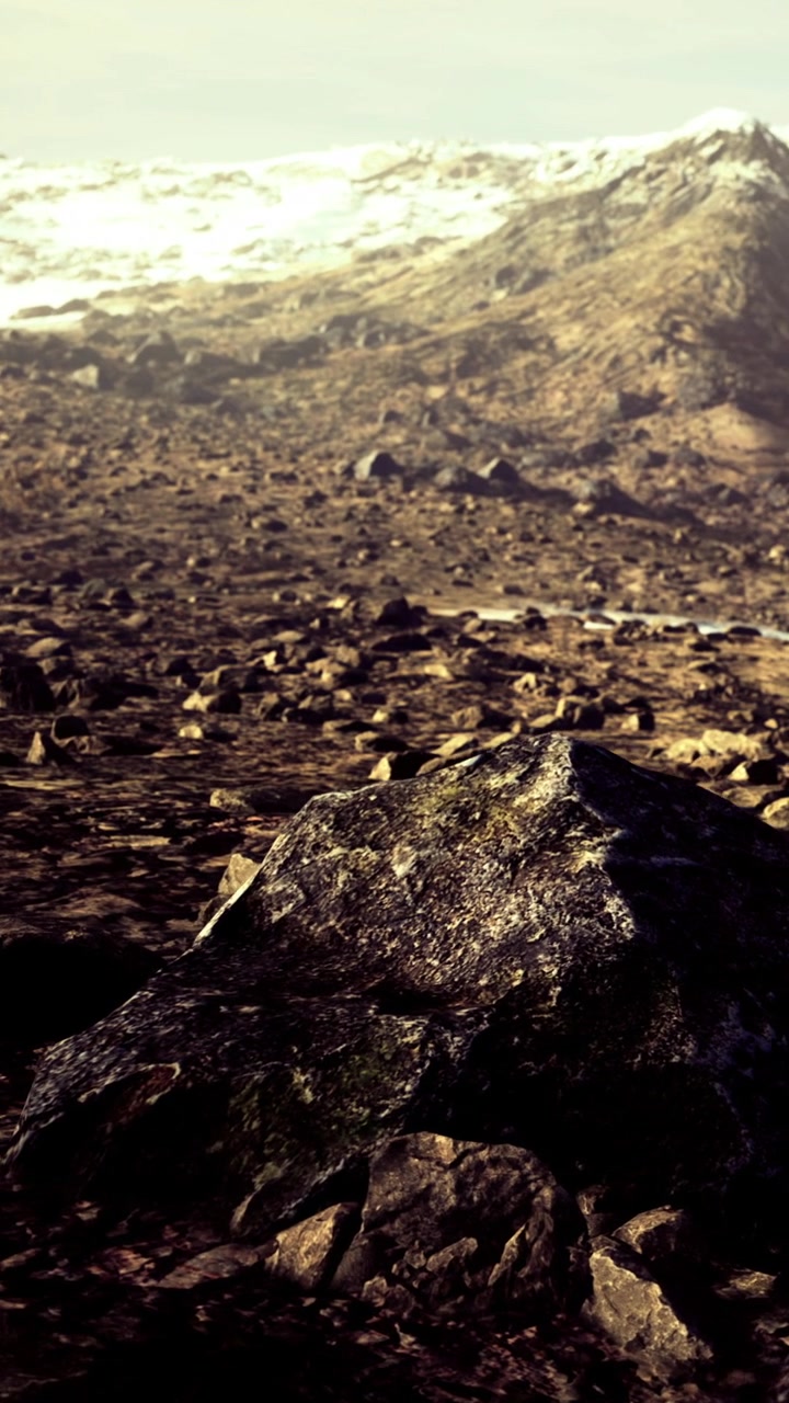 Terreno accidentato con rocce e montagne in lontananza di giorno.