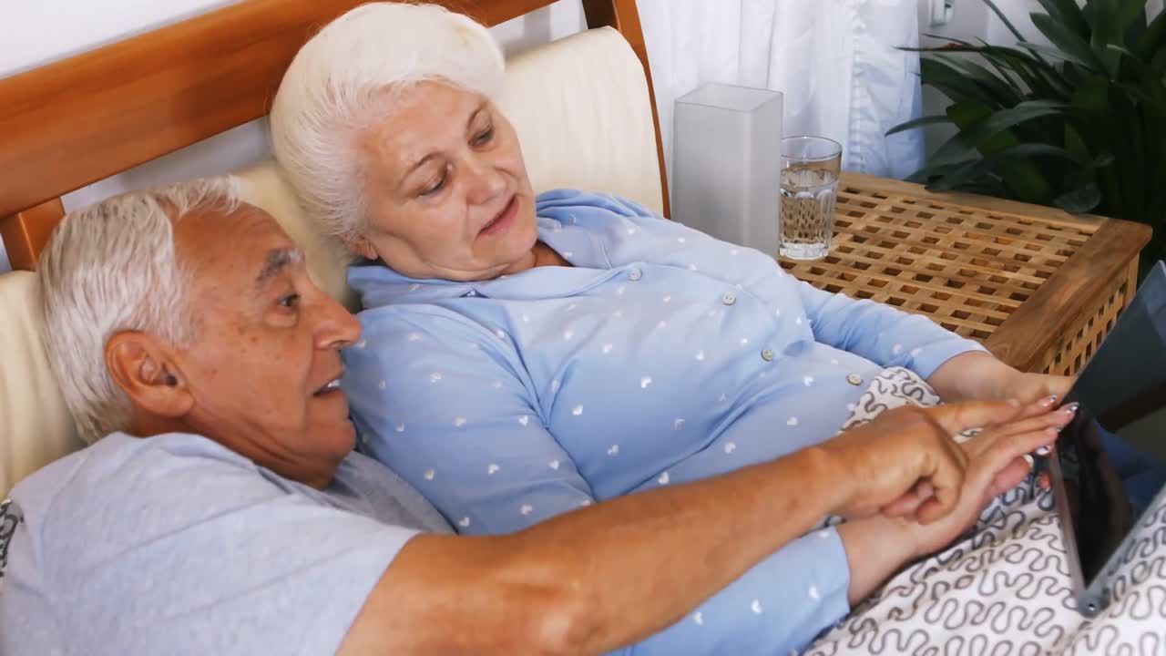 디지털 태블릿을 사용하는 고령 부부