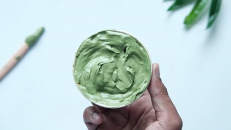 green clay face mask in a bowl