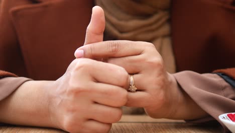 la mano de la mujer con el anillo dando pulgares hacia arriba